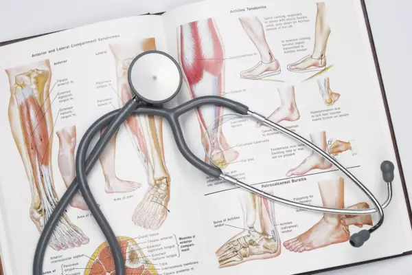 Stethoscope on anatomy textbook, highlighting lower leg and foot medical education and practice.